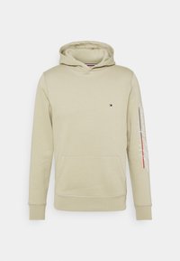 Felpa beige con cappuccio realizzata in tessuto morbido. Presenta una tasca frontale, polsini in costina e testo "Tommy Hilfiger" sulla manica.