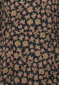 Tecido preto com uma estampa floral apresentando flores douradas com centros cor-de-rosa e contornos brancos. O padrão está densamente disposto por todo o tecido.