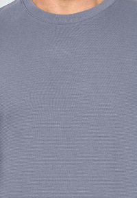 T-shirt du crewneck en gris clair texturé avec un col côtelé et de subtils rayures horizontales, fabriqué en tissu doux en mélange de coton.