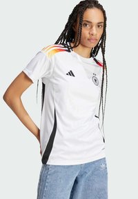 Bílý fotbalový dres s černými a barevnými bočními akcenty, kulatým výstřihem, krátkými rukávy a logem Adidas na hrudi.