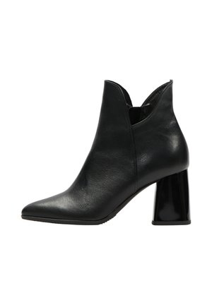 Melna ādas potīšu zābaki ar smailu purngalu, izgrebtu dizainu un spīdīgu bloku papēdi. Gluda virsma, elegants siluets.