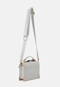 Sac à main blanc embossé crocodile avec ferrures dorées, une poignée supérieure et une bandoulière ajustable ; forme rectangulaire avec une texture lisse.