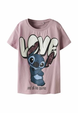 T-shirt en coton rose présentant un personnage de dessin animé bleu avec des contours noirs, un grand texte "AMOUR" et des accents de sequins sur les oreilles.