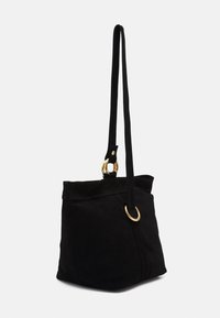 Sac fourre-tout en suède noir avec une longue bandoulière, des accents en métal doré, un détail à double anneau et une finition douce au toucher. Présente une forme simple et structurée.