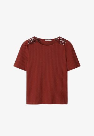 Chemise à manches courtes couleur rouille avec rayures verticales texturées et détails en dentelle découpée sur les épaules.