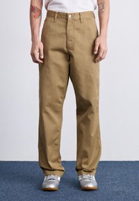 Khaki cotton pants with a straight fit, featuring front pockets, a zipper fly, and a single metal button closure. Textured fabric finish.