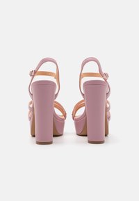 Rosa högklackade sandaler med en chunky platå, justerbara ankle straps och en slät texturerad yta. Öppen tå med lagerdesign detaljer.
