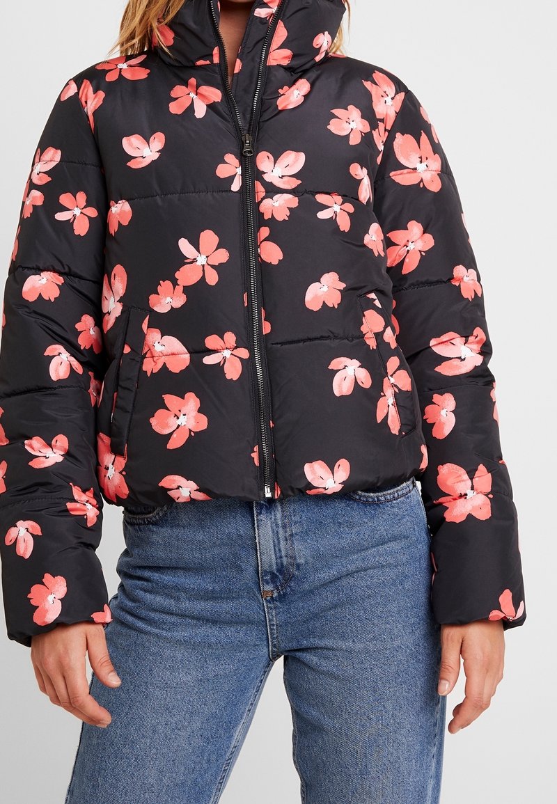 Svart puffjacka med rosa blommönster, med hög krage och dragkedjestängning. Texturerad, quiltad design med sidofickor.