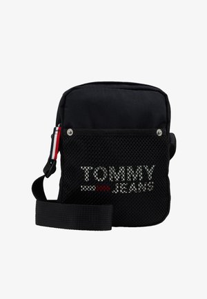 Bolso cruzado negro hecho de tela con un frente de malla. Presenta un logotipo en blanco y rojo, correa ajustable y acentos de botón a presión.