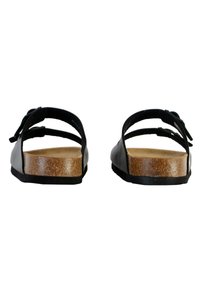 Sandali neri con due cinturini regolabili, una suola interna in sughero testurizzato e una suola piatta in gomma. Il design presenta uno stile minimalista e aperto.