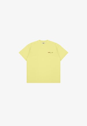 T-shirt de algodão amarelo com mangas curtas, decote redondo e pequeno texto impresso a castanho na área do lado esquerdo do peito. Design simples e sem adornos.