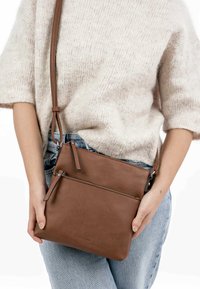 Borsa a tracolla in pelle marrone con superficie texture, due tasche con zip e una forma quadrata elegante. Spallaccio regolabile.