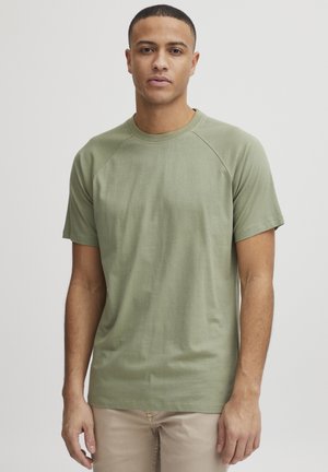 Olijfgroene t-shirt met korte mouwen, rond de hals en raglanmouwen, gemaakt van lichte stof met een gladde textuur.