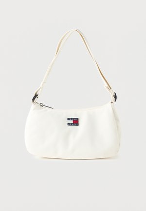 Biała torba na ramię z regulowanym paskiem i naszywką z logo Tommy Jeans na przedzie, na jednolitym tle.