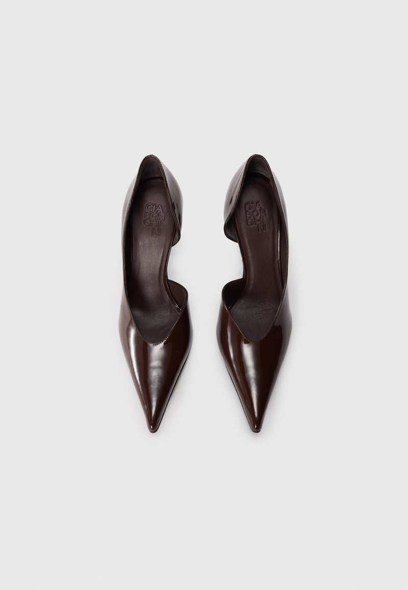 Braune Lackleder-High Heels mit spitzem Zehenbereich und niedrigem Schnitt. Glatte Textur, eleganter Schnitt und minimale Ausstattung.