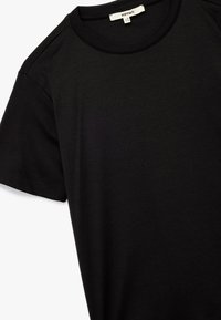 Zwarte katoenen T-shirt met een ronde halslijn en korte mouwen. Vlotte textuur met een klassieke pasvorm. Etiket zichtbaar bij de hals.