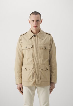 Beige Baumwolljacke mit einem kragenförmigen Halsauschnitt, zwei Brusttaschen und Knopfverschlüssen. Verfügt über Schulterklappen und eine lockere Passform.