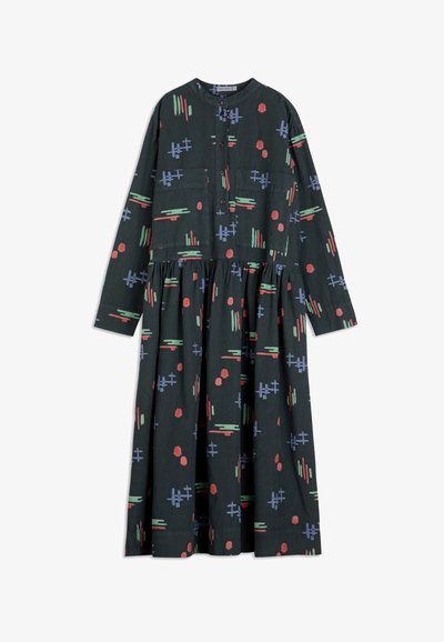 Robe à manches longues et boutons en tissu vert foncé avec une jupe à volants. Présente des motifs abstraits colorés en rouge, bleu et vert.