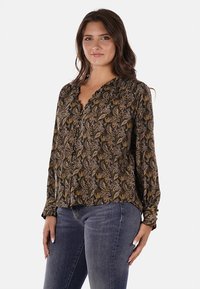 Blusa nera con intricato motivo paisley in oro e marrone, chiusura con bottoni sul davanti, tessuto morbido e maniche lunghe con polsini elasticizzati.