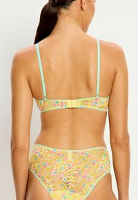 Ensemble de soutien-gorge en dentelle et culotte taille haute en jaune avec des motifs floraux multicolores ; bretelles en menthe ajustables ; fermeture à crochets au dos.