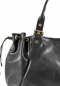 Sac en cuir noir avec fermeture à cordelette, œillets dorés et une sangle ajustable avec boucle dorée sur un fond blanc.