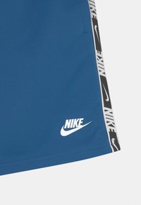 Nike Sportswear REPEAT - Teplákové kalhoty - dark marina blue/white