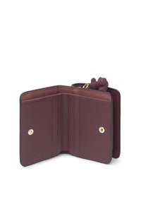 Cartera de cuero texturizado burdeos abierta que muestra múltiples ranuras para tarjetas, cierres de botón a presión y un pequeño charm en forma de oso adjunto.