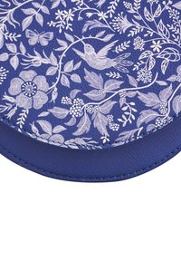 Plava kožna površina s bijelim uzorcima cvijeća, lišća, leptira i kolibrića u detaljnom, složenom dizajnu.