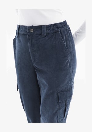 Pantaloni in corduroy blu scuro con vita elasticizzata, tasche laterali e dettagli con tasche cargo, caratterizzati da una texture morbida e un fit rilassato.