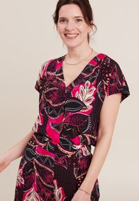 Abito con motivo floreale caratterizzato da colori vivaci come il rosa, il nero e il crema. Maniche corte, scollatura a V e dettagli con bottoni in vita.