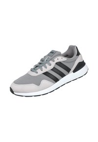 Zapatillas deportivas grises hechas de malla y ante, con franjas negras, cordones gris claro y suela blanca con parte inferior negra.