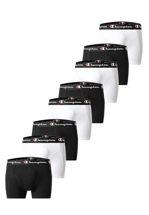 Sieben Paar schwarz-weißer Champion-Boxershorts mit gebrandeten Taillenbändern, abwechselnd in Farben angeordnet und diagonal auf weißem Hintergrund gestapelt.