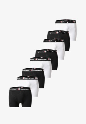 Sieben Paar schwarz-weißer Champion-Boxershorts mit gebrandeten Taillenbändern, abwechselnd in Farben angeordnet und diagonal auf weißem Hintergrund gestapelt.