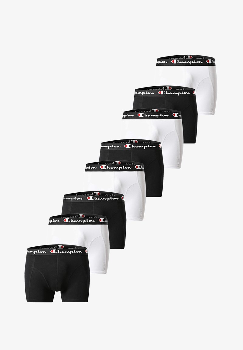 Sieben Paar schwarz-weißer Champion-Boxershorts mit gebrandeten Taillenbändern, abwechselnd in Farben angeordnet und diagonal auf weißem Hintergrund gestapelt.