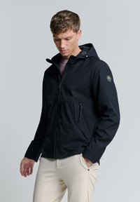 Zwarte zipjack met capuchon, met een gestructureerde afwerking, voorzakken met rits en een hexagonaal logo-obstakel op de linkerschouder.