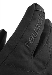 Black fabric glove with textured surface and embroidered "reusch" logo on the thumb. Features a curved design and sleek finish.