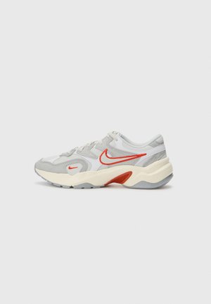 Grå och vita Nike-sneakers med röda accenter, texturerat material, vadderad krage, flexibel sula och en bred form för komfort och stöd.