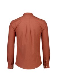 Camisa de manga larga, abotonada, en tela de color óxido. Presenta un cuello clásico, un pliegue central en la parte posterior y un dobladillo redondeado con puños abotonados.
