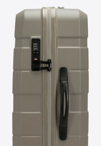 Šedý tvrdý kufr s texturovaným povrchem, dvojitými zipy, kombinovaným zámkem a černou rukojetí po straně. Obdélníkový tvar.