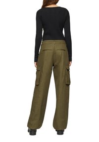 Zwarte geribbelde longsleeve top, gecombineerd met hooggewaiste, wijde olijfgroene cargobroek met zijzakken en een gladde textuur.