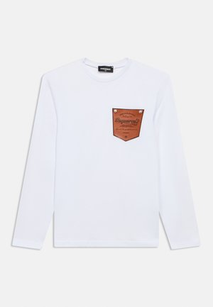 Witte lange mouwen T-shirt met een bruin leren patch op de borst met geperst tekst en twee metalen studs aan de randen.