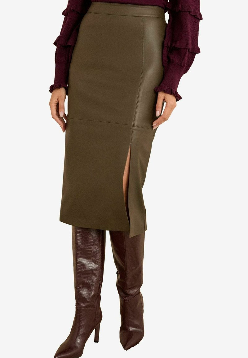 Olivroheline sünteetilisest nahast pliiatsiseelik külje lõhega, kombineeritud läikivate burgundia värvi põlvekõrguste saapatega, millel on tekstuurne viimistlus.