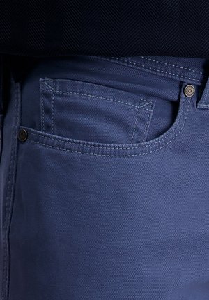 Blauwe katoenen denim jeans met een standaard voorzak, versterkte stiksels en een metalen knoopaccent op de tailleband.
