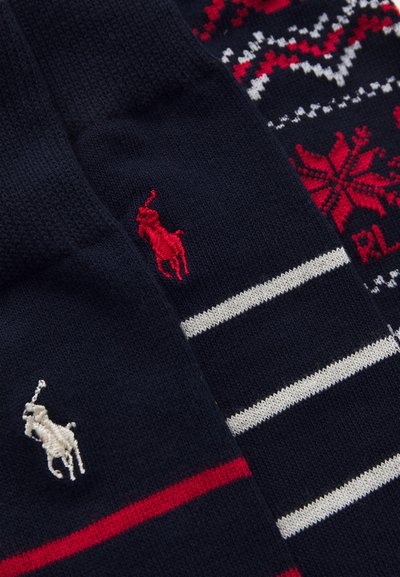 Due paia di calzini blu navy; uno presenta un motivo a righe rosse e bianche, l'altro ha strisce rosse e bianche, entrambi con loghi ricamati.