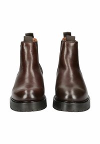 Bottines en cuir brun avec des panneaux latéraux élastiques, bout rond et semelle en caoutchouc noir épaisse. Texture lisse sans motifs visibles.