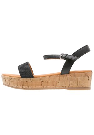 Schwarze Plateausandalen mit strukturiertem Obermaterial, verstellbarem Knöchelriemen und Kork-Wedge-Sohle. Glatte Innenauskleidung und flache Außensohle.