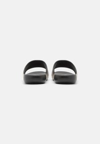 Sorte gummi slip-on sandaler med en glat overflade, åben bagside og brede stropper; designet til komfort og nem påføring.