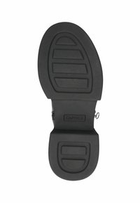 Suela de zapato negra con agarre texturizado, que presenta estrías horizontales y verticales. Incluye un logotipo y una sección de tacón pronunciada.