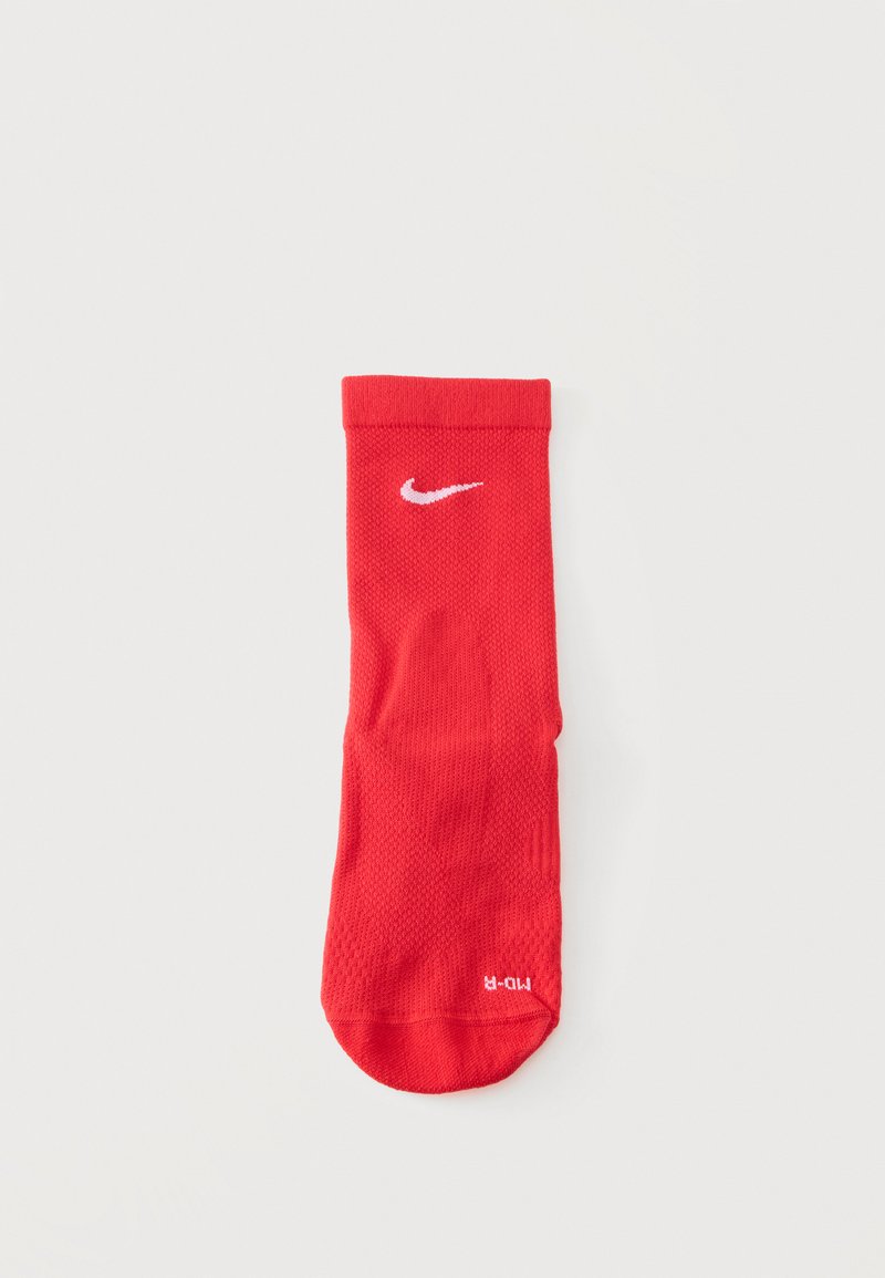 Κόκκινη αθλητική κάλτσα Nike με λευκό λογότυπο Swoosh κοντά στο επάνω μέρος και σήμανση μεγέθους στην περιοχή των δαχτύλων, επίπεδη σε λευκό φόντο.