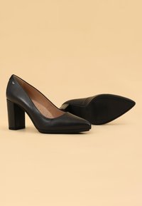 Décolleté nere in pelle con tacco a stiletto e punta affusolata. Interno con soletta imbottita e texture a pois. Suola in gomma.
